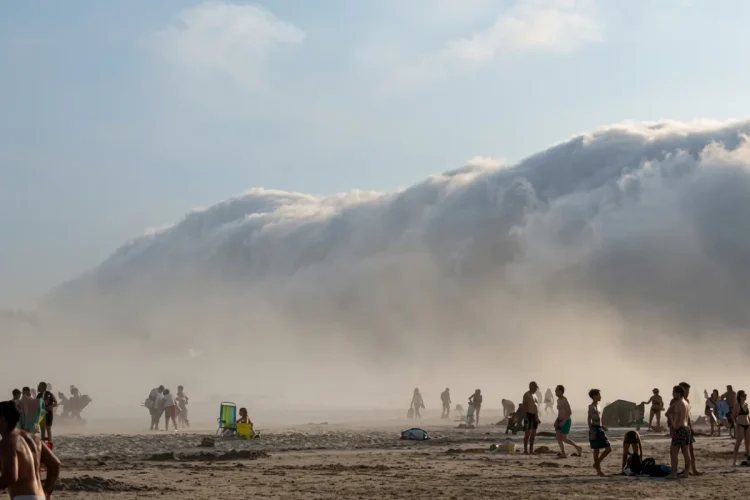 Fitta nebbia avvolge la spiaggia affollata di persone curiosi.
