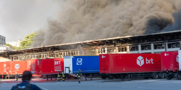 Vigili del fuoco spengono grande incendio camion Bartolini a Milano. Maxi incendio al deposito Bartolini a Milano, il rogo sarebbe partito da un pacco caricato su un camion