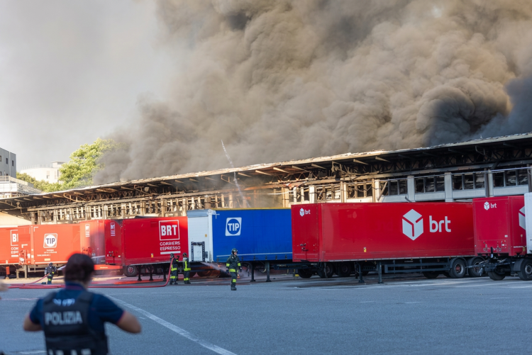 Vigili del fuoco spengono grande incendio camion Bartolini a Milano. Maxi incendio al deposito Bartolini a Milano, il rogo sarebbe partito da un pacco caricato su un camion