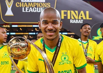 Calciatore sudafricano sorride, mostra trofeo CAF Champions League, festeggia vittoria
