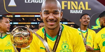 Calciatore sudafricano sorride, mostra trofeo CAF Champions League, festeggia vittoria