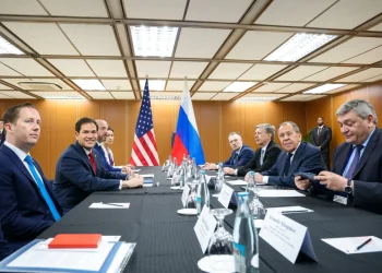 Lavrov e Rubio siedono al tavolo con bandiere USA e Russia sullo sfondo.