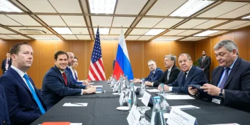 Lavrov e Rubio siedono al tavolo con bandiere USA e Russia sullo sfondo.