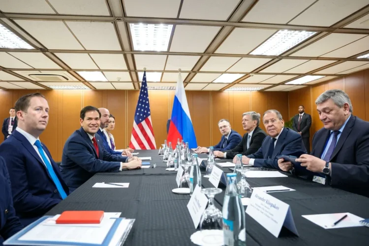 Lavrov e Rubio siedono al tavolo con bandiere USA e Russia sullo sfondo.