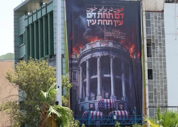 Manifesto anti-USA con Casa Bianca in fiamme e bare avvolte bandiera americana.