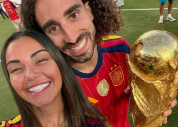 Coppia sorridente con maglia della Spagna e trofeo dorato sul campo