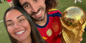 Coppia sorridente con maglia della Spagna e trofeo dorato sul campo