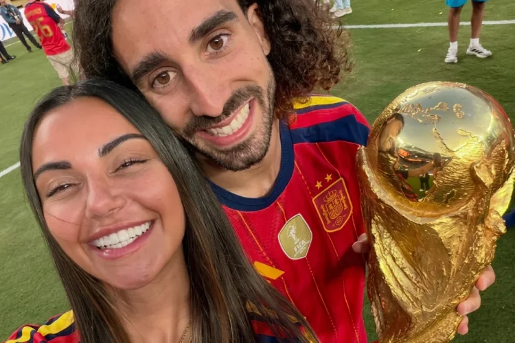 Coppia sorridente con maglia della Spagna e trofeo dorato sul campo