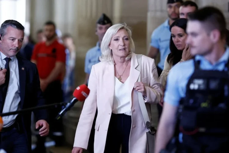 Marine Le Pen parla mentre cammina tra la folla e la sicurezza