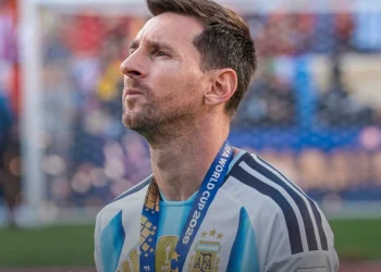 Lionel Messi pensieroso in campo con maglia Argentina, lanyard FIFA.