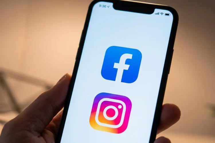 Smartphone mostra loghi Facebook e Instagram su sfondo bianco.