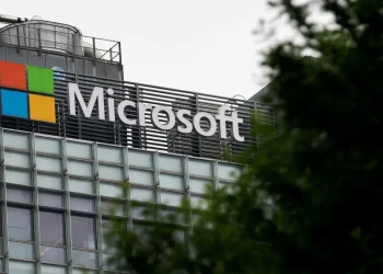 Insegna con logo e nome di Microsoft su edificio moderno, parzialmente coperta.