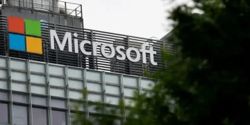 Insegna con logo e nome di Microsoft su edificio moderno, parzialmente coperta.