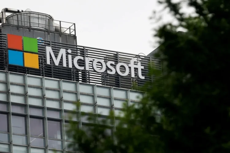 Insegna con logo e nome di Microsoft su edificio moderno, parzialmente coperta.