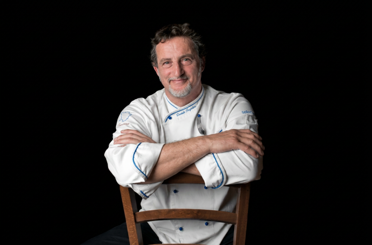 Daniele Fagiolini chef sorridente in giacca bianca con forchetta. Il mondo della cucina in lutto, si è spento lo chef Daniele Fagiolini: addio al talento toscano