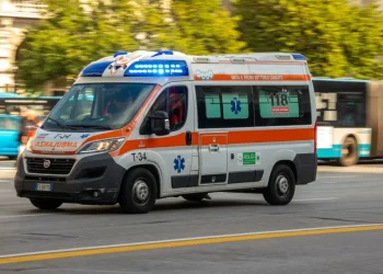 Ambulanza bianca e arancione in movimento con luci blu accese