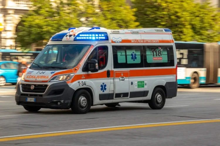 Ambulanza bianca e arancione in movimento con luci blu accese