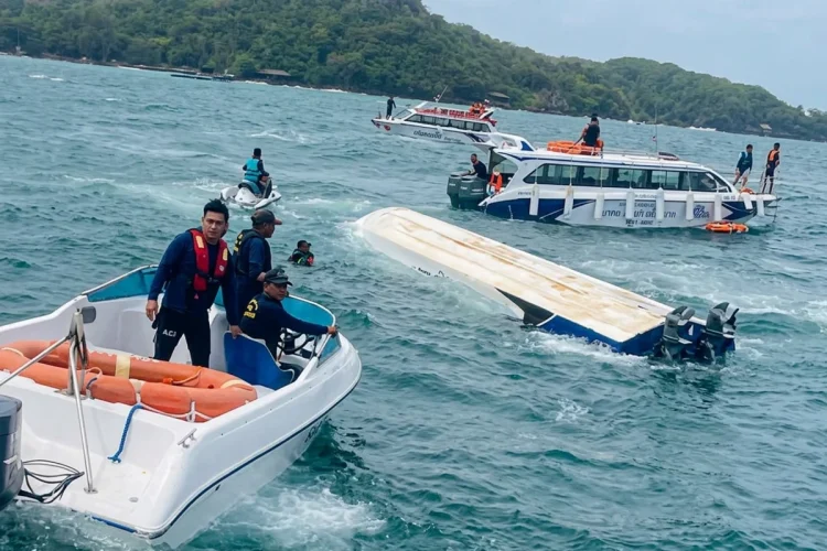 Uomini su barche soccorrono una barca capovolta in mare aperto