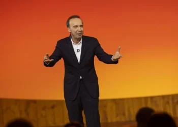 Roberto Benigni gesticola sul palco con un completo scuro