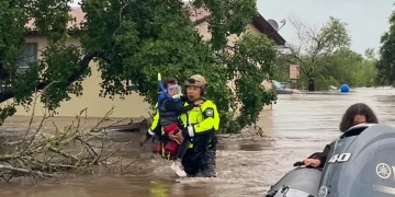 Soccorritore salva bambino mascherato dall'alluvione, acqua alta
