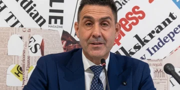 Roberto Vannacci in conferenza stampa con sfondo di ritagli di giornale