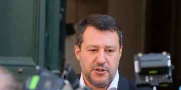 Matteo Salvini in primo piano parla a giornalisti con microfoni