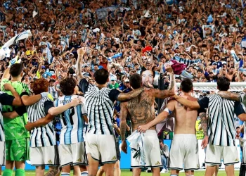 Una squadra di calcio argentina abbracciata festeggia una vittoria sul campo.