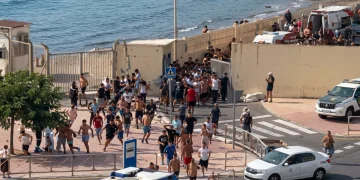 Folla di migranti corre verso recinzione a Ceuta, Spagna