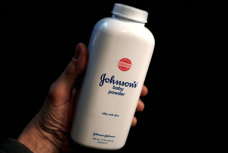 Mano regge flacone di talco Johnson & Johnson baby powder. Johnson & Johnson offre 5,5 miliardi per chiudere le cause sul talco cancerogeno