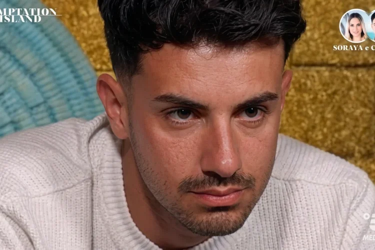 Cristian di Temptation Island guarda pensieroso durante un filmato.