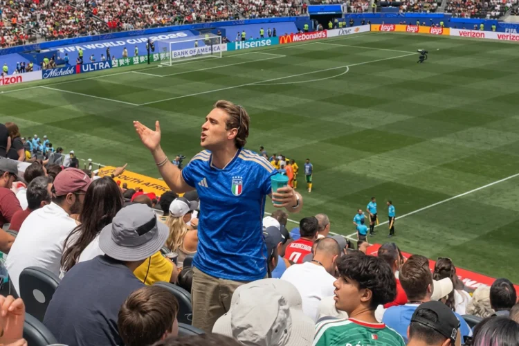 Tifoso italiano con maglia azzurra gesticola allo stadio durante una partita
