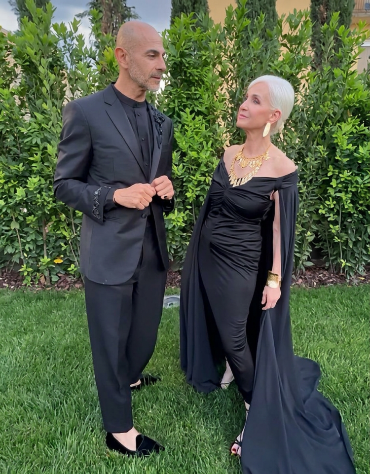 Enzo Miccio e Maelle Rocchi su prato in abiti neri eleganti. Ma come ti vesti? torna su Real Time dopo 18 anni con Enzo Miccio e Carla Gozzi
