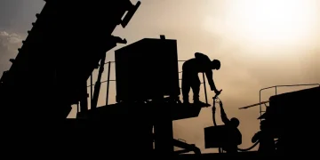 U.S. Army Soldiers work to refuel a generator at a base in the Middle East