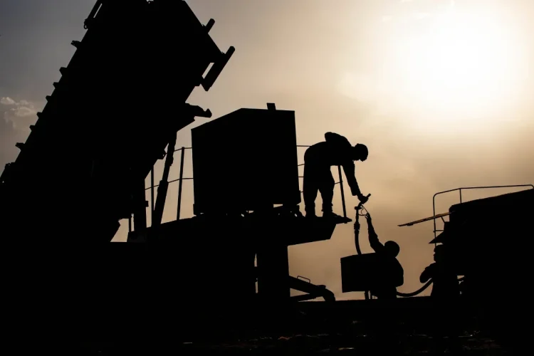 U.S. Army Soldiers work to refuel a generator at a base in the Middle East