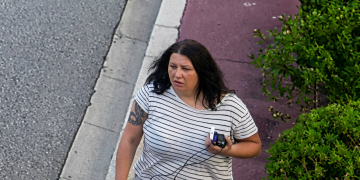 Anastasia Berezovska cammina in strada con tatuaggio sul braccio