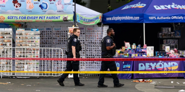 Due agenti di polizia camminano sul luogo di una sparatoria a Seattle. Sparatoria a Seattle: tre morti e quattro feriti. Un arresto