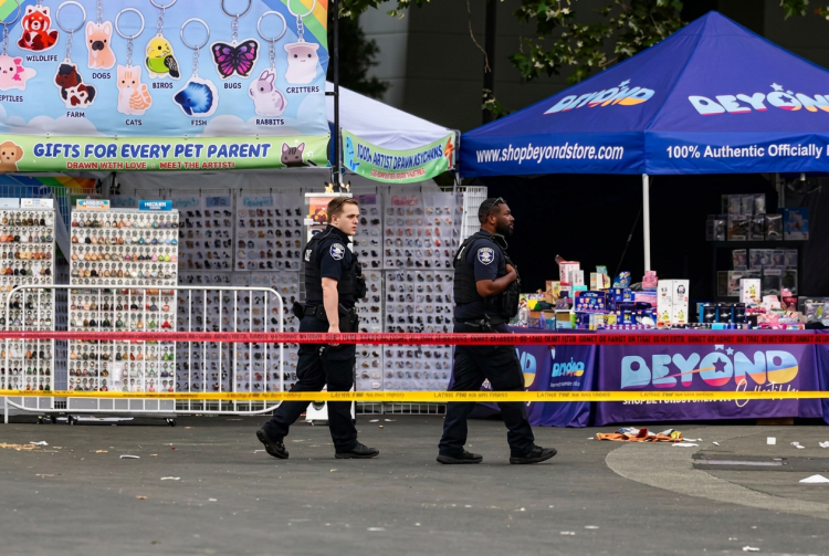 Due agenti di polizia camminano sul luogo di una sparatoria a Seattle. Sparatoria a Seattle: tre morti e quattro feriti. Un arresto