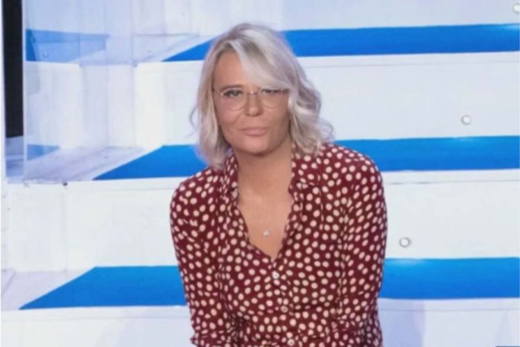 Maria De Filippi seduta sulle scale di Uomini e Donne