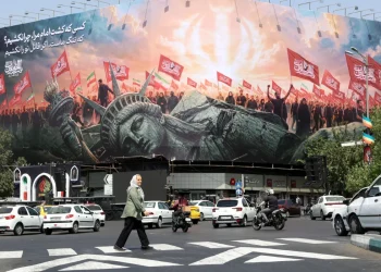 An Iranian elderly woman walks past an anti-US billboard at Enghelab Square in central Tehran, Iran, 03 August 2026