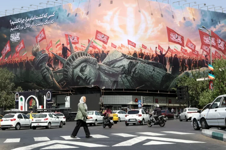 An Iranian elderly woman walks past an anti-US billboard at Enghelab Square in central Tehran, Iran, 03 August 2026