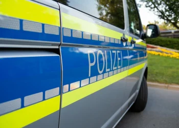 Furgone della polizia tedesca blu e giallo con scritta "Polizei" su strada.