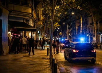 Auto della polizia in strada a Barcellona di notte con persone