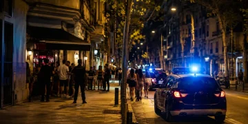 Auto della polizia in strada a Barcellona di notte con persone