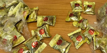 Confezioni dorate di biscotti della fortuna contenenti cocaina su un tavolo