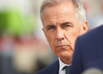 Uomo anziano in abito scuro e cravatta, sguardo serio