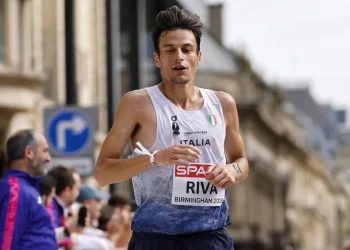 Pietro Riva corre una maratona con canotta Italia e pettorale.