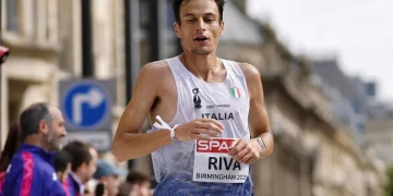Pietro Riva corre una maratona con canotta Italia e pettorale.