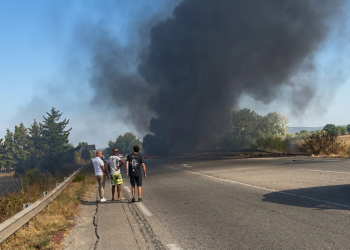 Uomini osservano denso fumo nero da incidente a bordo strada. Atterraggio d'emergenza a Salon-de-Provence: aereo dell'Aeronautica militare prende fuoco