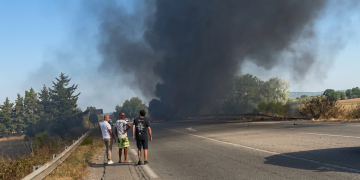 Uomini osservano denso fumo nero da incidente a bordo strada. Atterraggio d'emergenza a Salon-de-Provence: aereo dell'Aeronautica militare prende fuoco