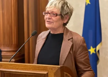 Annamaria Furlan parla da un podio con bandiere italiana ed europea.